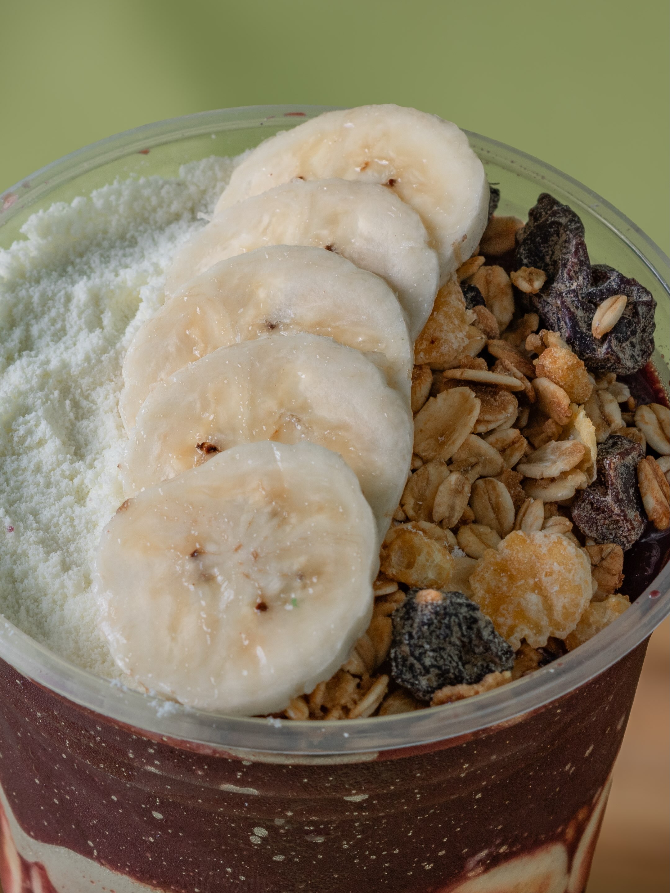 Açaí com banana em rodelas, leite em pó e granola