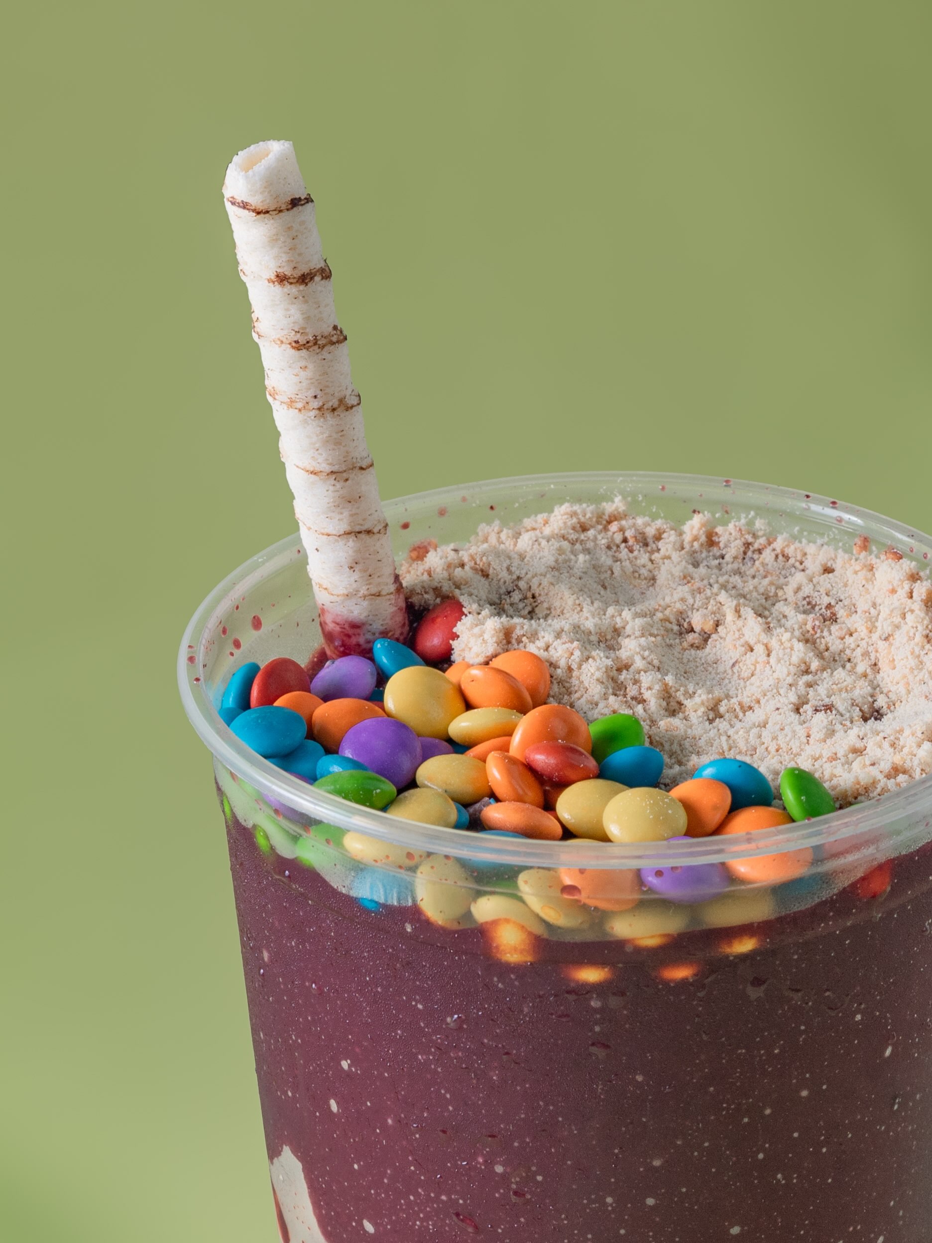 Açaí com confeitos coloridos, leite em pó e canudo de wafer