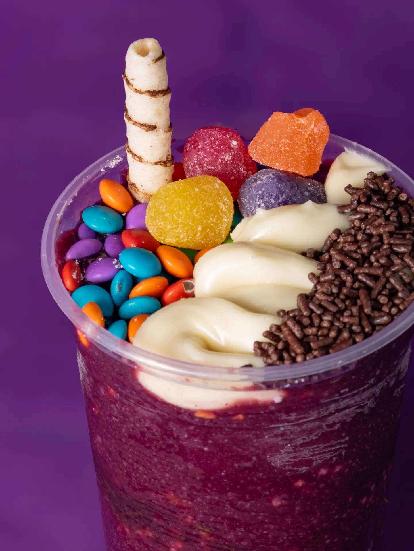 Açaí com creme, confeitos coloridos, jujubas e granulado